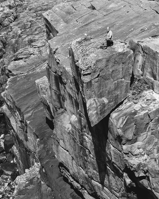 Brian D Hodgson standing on cliffside rock
